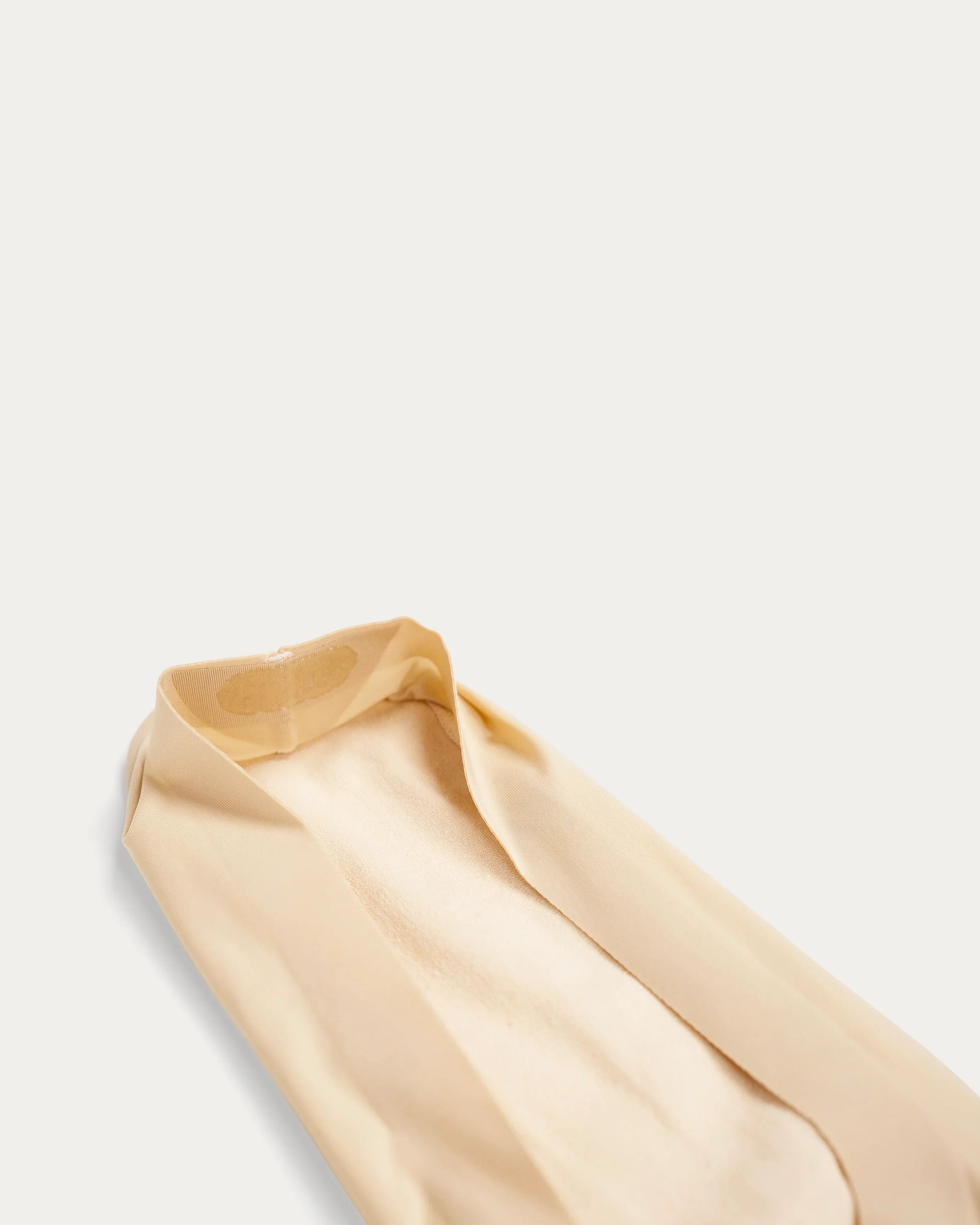 Beige sheer pantyhose with reinforced toe and smooth texture, ideal for everyday wear